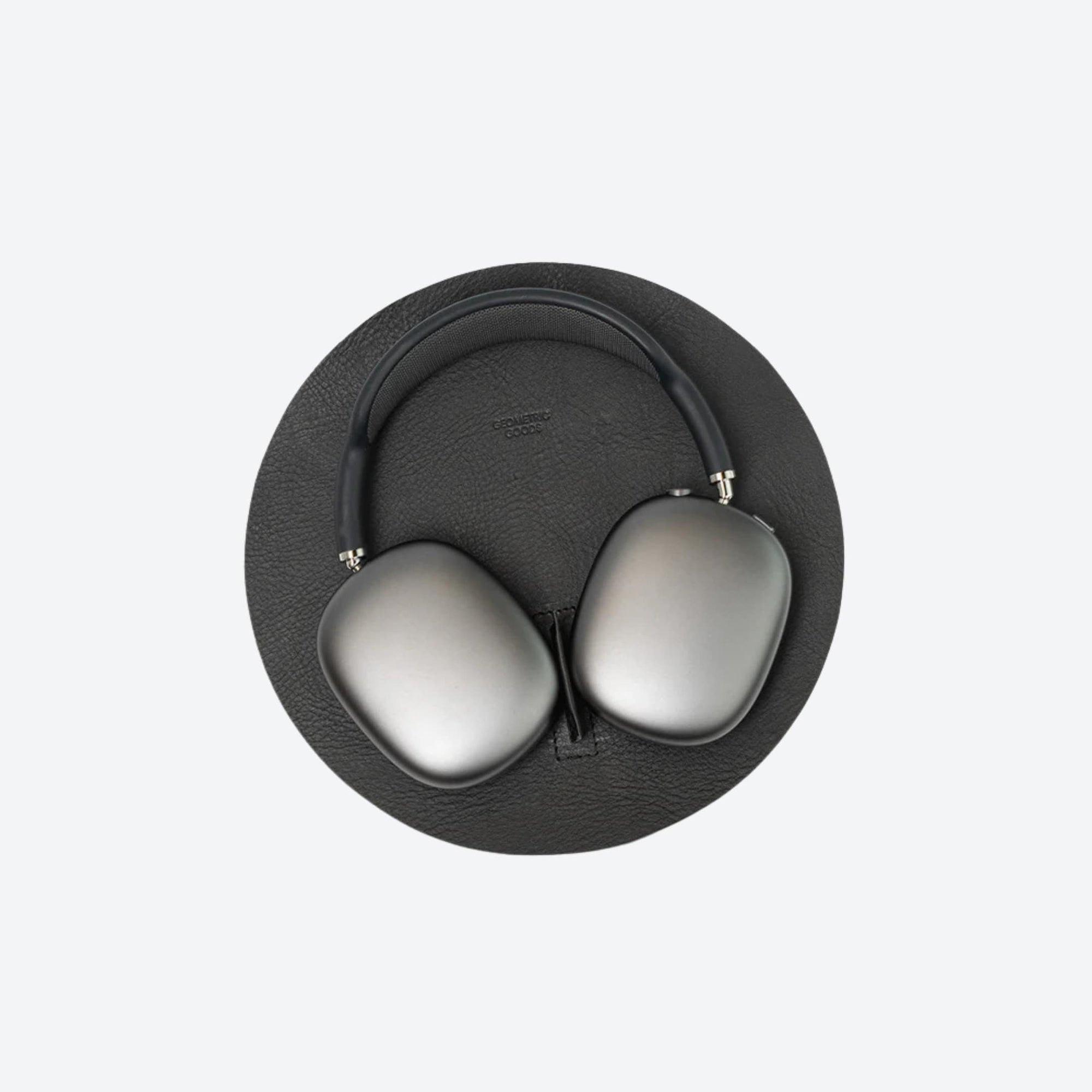 Black headphones with gray ear pads on a light gray background