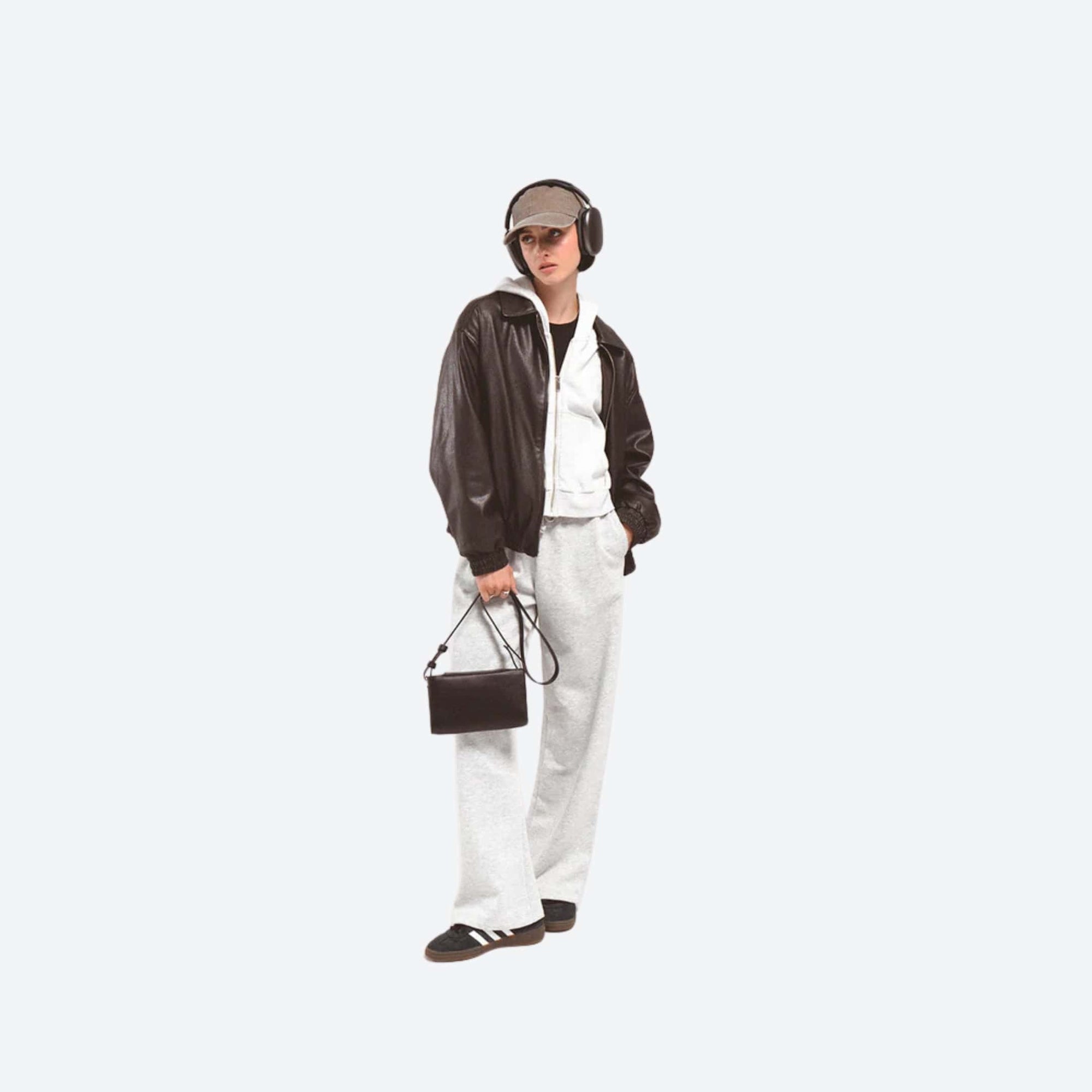 Person wearing a brown jacket, white pants, and headphones on a white background